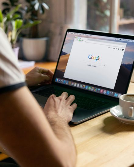 This image depicts a person using Google search on their laptop.
